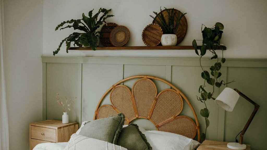 Plantas no quarto sobre prateleira, acima de cabeceira de palhinha