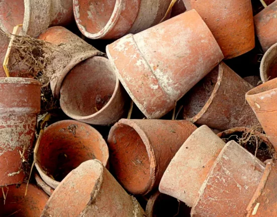 Pilha de vasos de barro velhos e tombados, com manchas e bordas esbranquiçadas na superfície do barro.